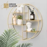 رف جداري دائري من الاستيل مذهب حاجز جداري الأبعاد: رف جداري بمقاساته الفريدة، يأتي الرف بعرض 60 سم، ارتفاع 60 سم، وعمق 14 سم، مما يجعله مناسبًا لتنسيقه في معظم الأماكن داخل منزلك بشكل مثالي. ارفف ديكور اللون الذهبي: يأتي رف جداري من اركان القصر بلون ذهبي فاخر يضفي لمسة من الفخامة والدفء إلى أي مكان تقرر وضعه. يمكنك تنسيقه بسهولة مع مختلف أنماط الديكور لديك، مما يجعله اختيارًا رائعًا لتحسين جمالية المكان.